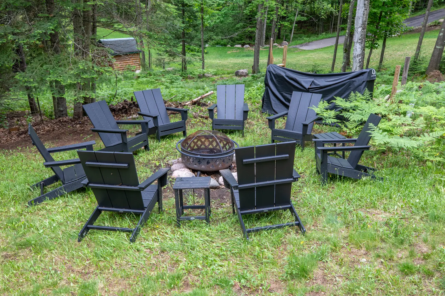 Firepit ringed with Adirondack chairs